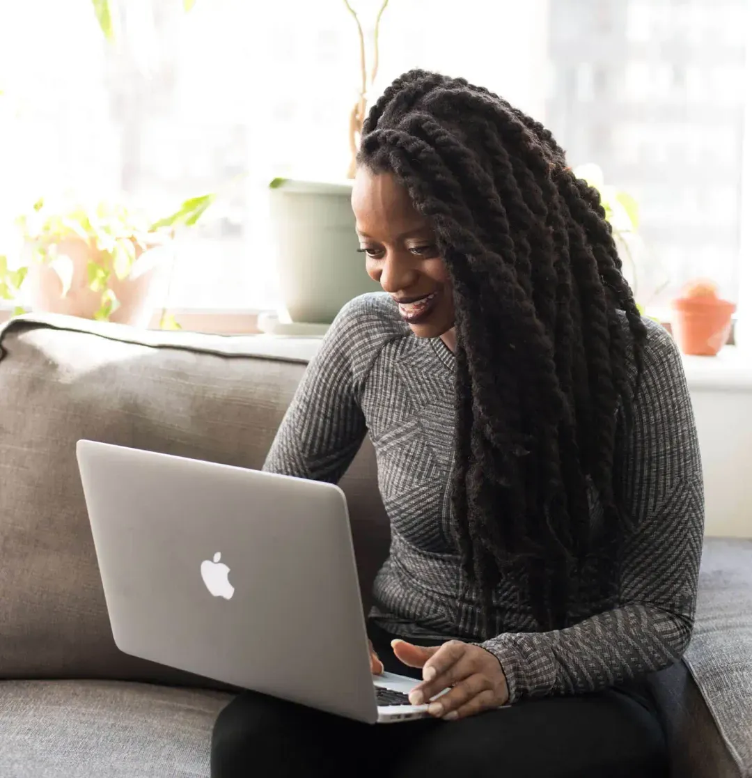 A woman smiling using a laptop