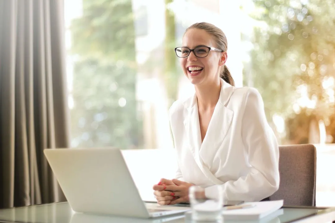 A woman smiling using a laptop