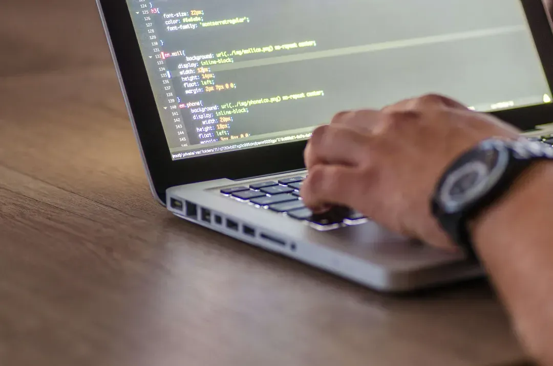 A developer coding on a laptop